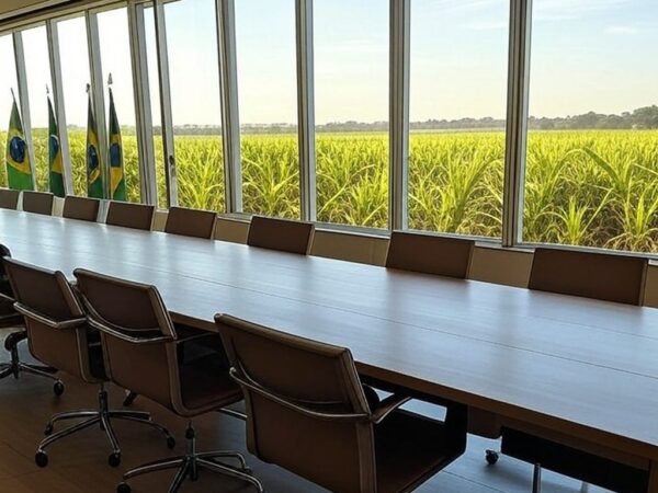 Sala de reuniões vazia com vista para campos agrícolas no Brasil, representando encontro sobre agronegócio.