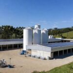 Granja moderna de proteínas animais em Chapecó, com instalações inovadoras e paisagem rural brasileira.