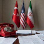 Telefone vermelho em mesa diplomática com bandeiras simbolizando ligação sobre cessar-fogo com o Irã