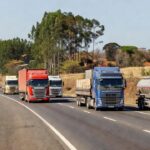 Caminhões de carga em rodovia brasileira sobre custos de frete