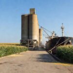 Porto com silos e navio para exportação de milho com preços estáveis